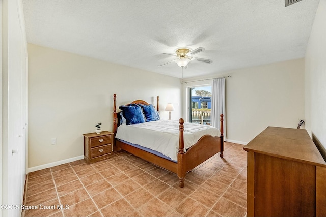 bedroom with light tile patterned flooring, a textured ceiling, a ceiling fan, and baseboards