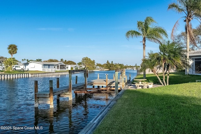 dock area with a yard and a water view