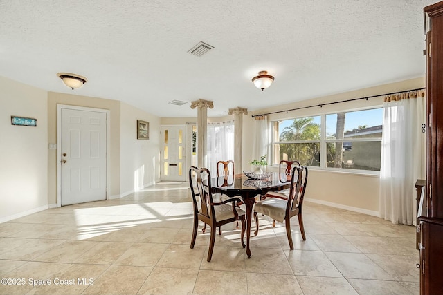 dining space with visible vents, baseboards, a textured ceiling, and light tile patterned flooring