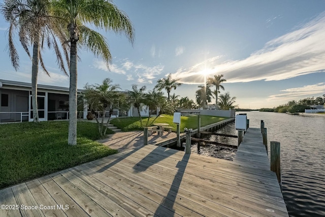 dock area featuring a lawn and a water view