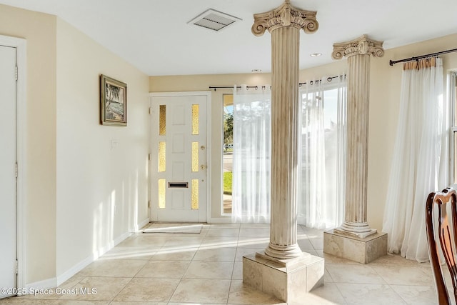 entrance foyer with decorative columns, light tile patterned flooring, visible vents, and baseboards