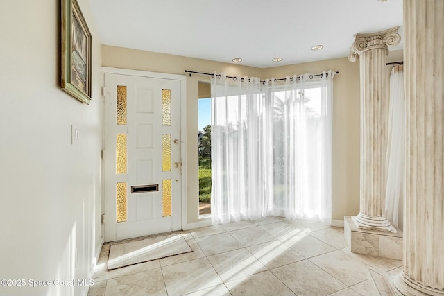 entryway with tile patterned floors and decorative columns