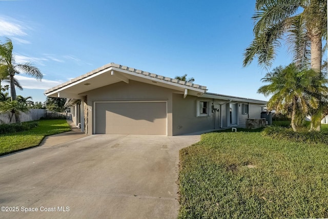 ranch-style house with stucco siding, fence, concrete driveway, a front yard, and an attached garage