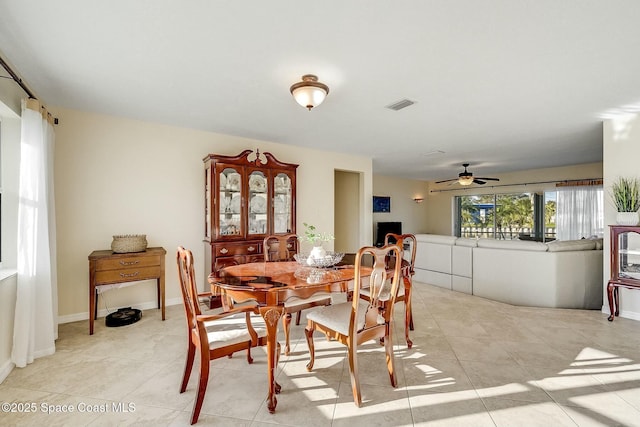 dining space with light tile patterned floors, visible vents, and ceiling fan