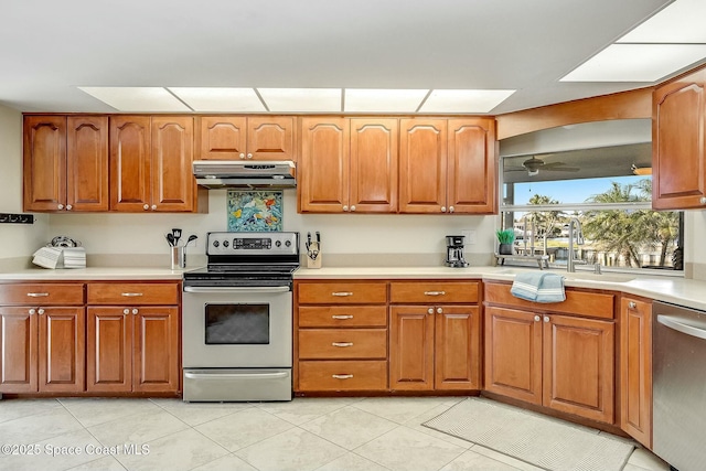 kitchen with a sink, light countertops, under cabinet range hood, and stainless steel appliances