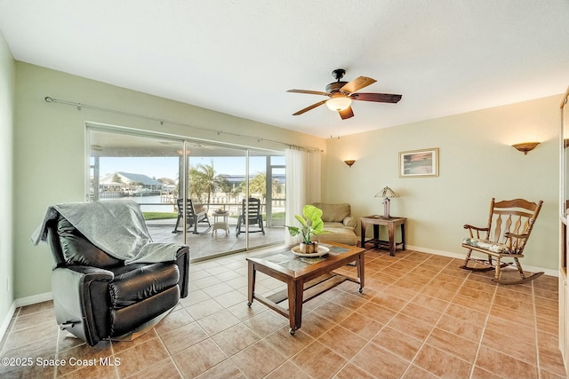 living room featuring light tile patterned flooring, baseboards, and a ceiling fan