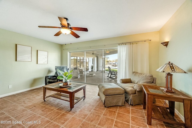 living area with light tile patterned floors, baseboards, and ceiling fan