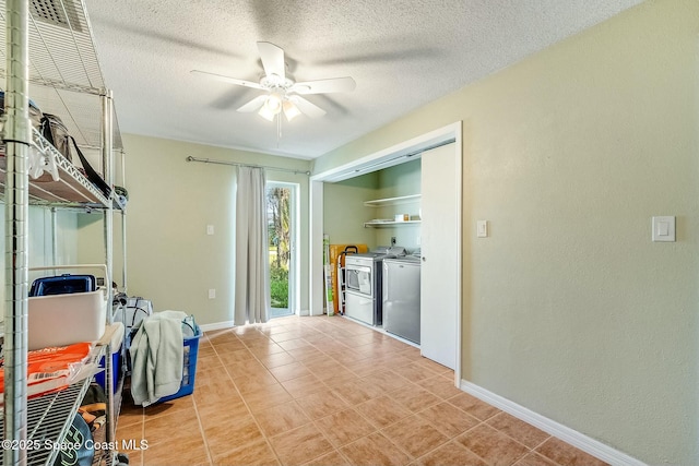 interior space featuring washer and dryer, baseboards, a textured ceiling, and ceiling fan