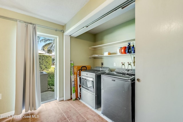 clothes washing area featuring light tile patterned floors, separate washer and dryer, and laundry area