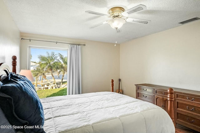 bedroom with visible vents, a textured ceiling, ceiling fan, and access to outside