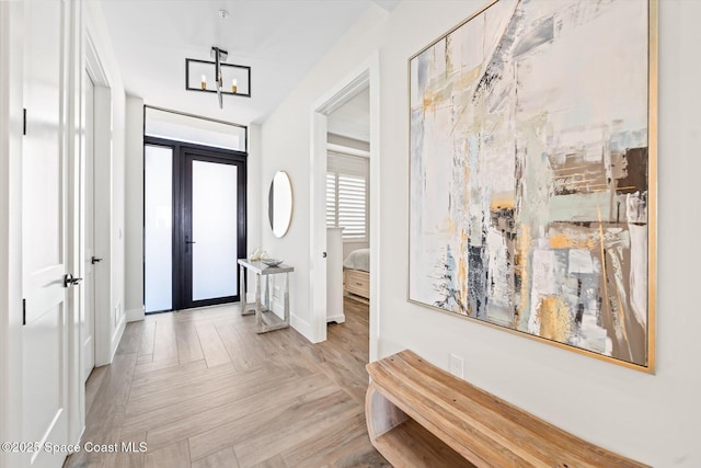 entrance foyer with a notable chandelier, french doors, and baseboards