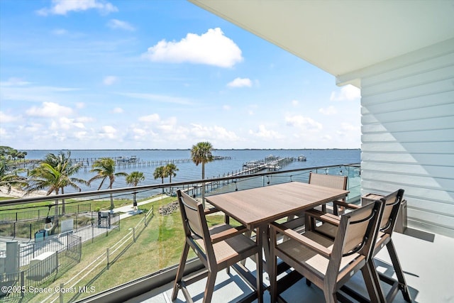 balcony featuring outdoor dining space and a water view