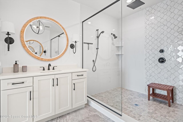 bathroom featuring marble finish floor, vanity, and walk in shower