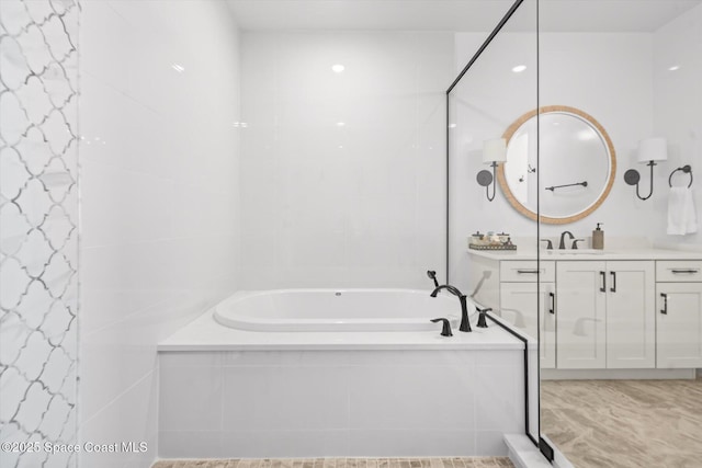 full bath featuring vanity and a garden tub