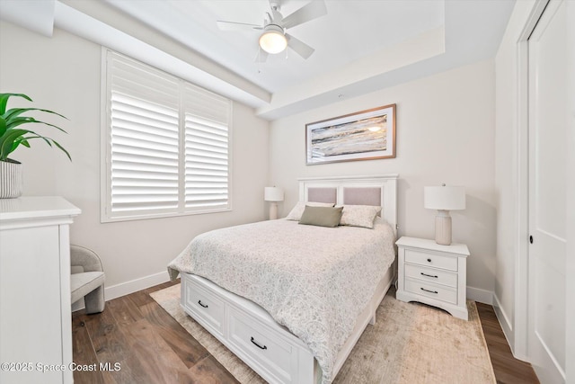 bedroom featuring a ceiling fan, wood finished floors, baseboards, and a closet