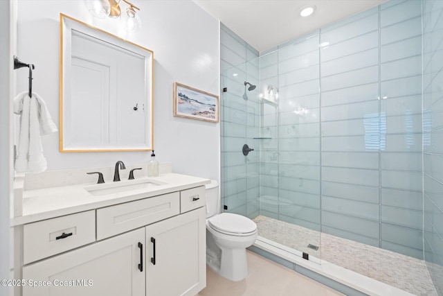 full bath with tiled shower, toilet, vanity, and tile patterned flooring