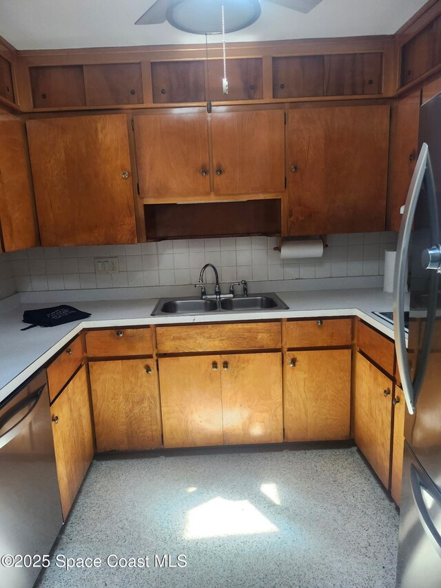 324 Harbor Dr, Cape Canaveral, FL 32920 - kitchen with a sink, appliances with stainless steel finishes, light countertops, decorative backsplash, and brown cabinets