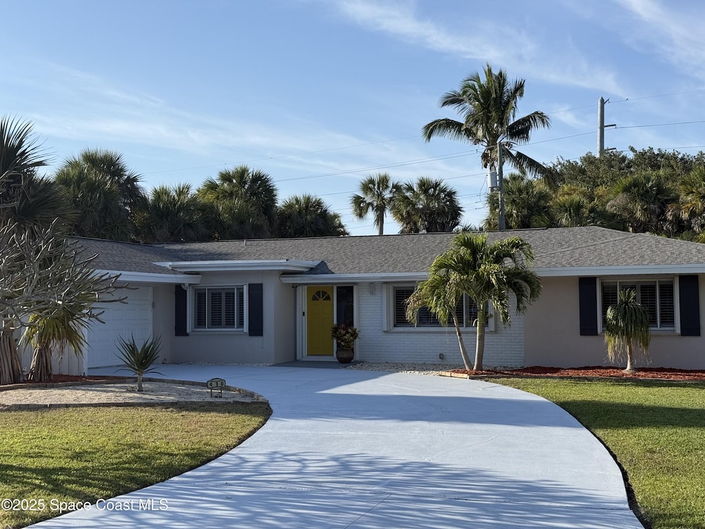 ranch-style house with a shingled roof, stucco siding, concrete driveway, a front lawn, and a garage