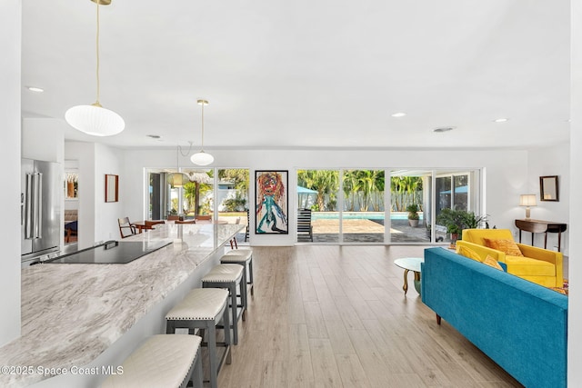 living area with a wealth of natural light, recessed lighting, and light wood-style flooring