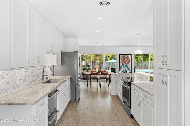 kitchen with a healthy amount of sunlight, visible vents, electric range, a sink, and decorative backsplash