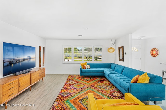 living area with baseboards and light wood finished floors