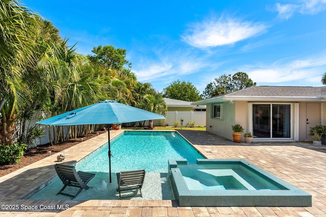 view of swimming pool with a patio area, a pool with connected hot tub, and a fenced backyard