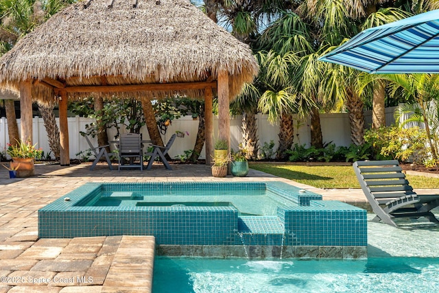 view of pool with a pool with connected hot tub, a gazebo, outdoor dining area, a fenced backyard, and a patio area