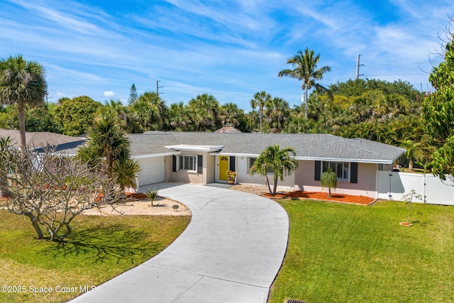 ranch-style home with fence, concrete driveway, a front yard, stucco siding, and a gate
