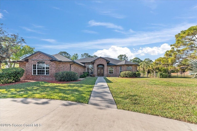 view of front of property featuring brick siding and a front yard