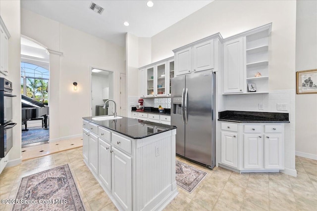 kitchen with visible vents, stainless steel refrigerator with ice dispenser, a sink, open shelves, and white cabinets