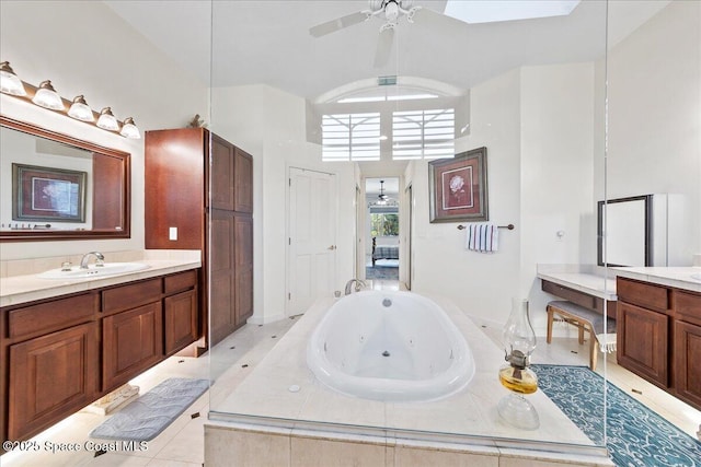 full bath with vanity, a jetted tub, and a ceiling fan