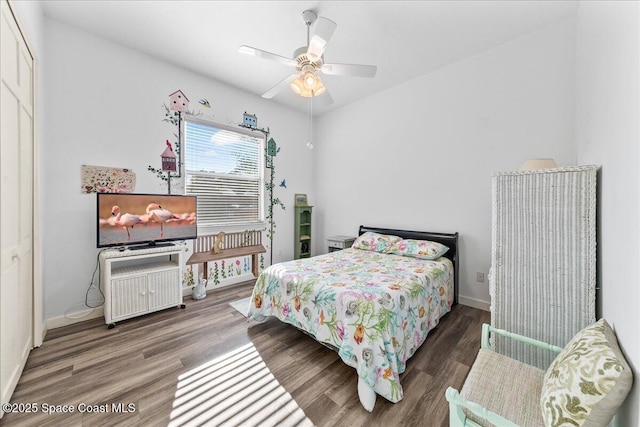 bedroom featuring baseboards, wood finished floors, and a ceiling fan