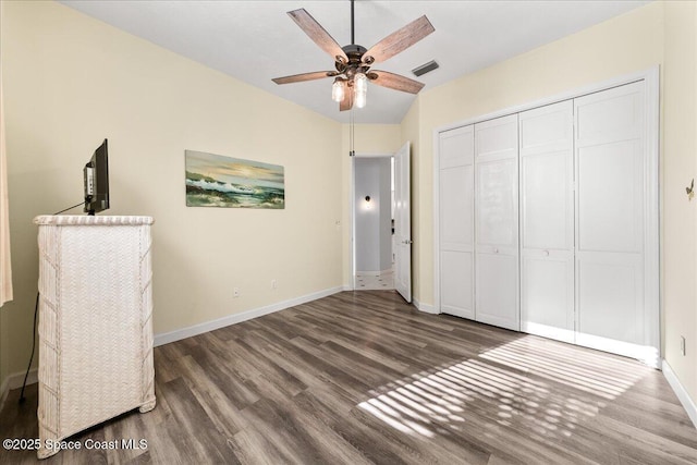 unfurnished bedroom featuring visible vents, baseboards, wood finished floors, a closet, and a ceiling fan