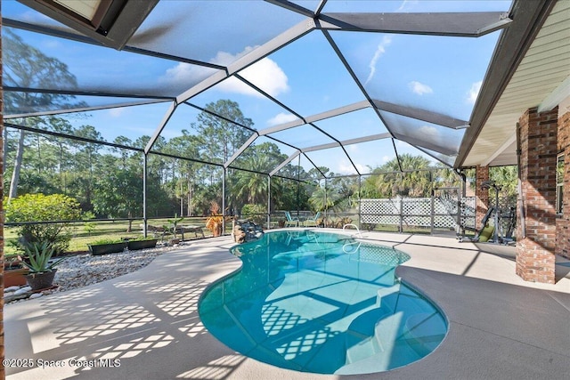 pool featuring glass enclosure and a patio area