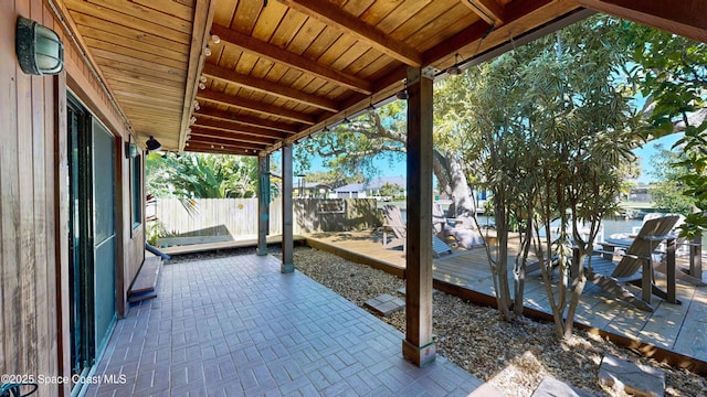 view of patio with a wooden deck and fence