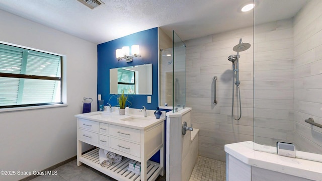 bathroom featuring a sink, visible vents, double vanity, and a walk in shower