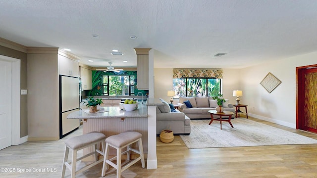 living room featuring recessed lighting, visible vents, baseboards, and light wood-style flooring