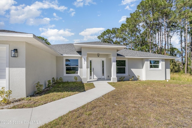 531 Ortega St SE, Palm Bay, FL 32909 - view of front facade with a shingled roof, a front lawn, and stucco siding