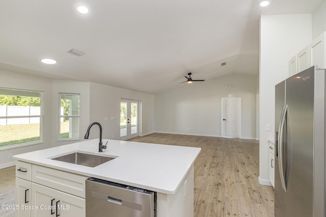 531 Ortega St SE, Palm Bay, FL 32909 - kitchen featuring appliances with stainless steel finishes, white cabinetry, light wood-style floors, and a sink