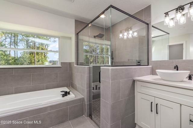 531 Ortega St SE, Palm Bay, FL 32909 - full bathroom with a garden tub, a stall shower, tile walls, tile patterned flooring, and vanity