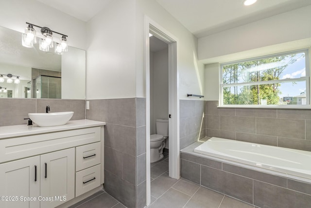 531 Ortega St SE, Palm Bay, FL 32909 - full bath featuring vanity, a garden tub, tile patterned floors, toilet, and tile walls