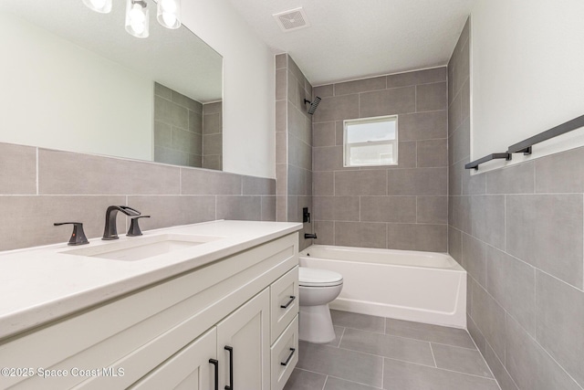 531 Ortega St SE, Palm Bay, FL 32909 - bathroom featuring tile patterned floors, toilet, tile walls, bathing tub / shower combination, and vanity