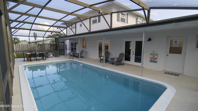 view of pool featuring a patio area, french doors, fence, and a lanai