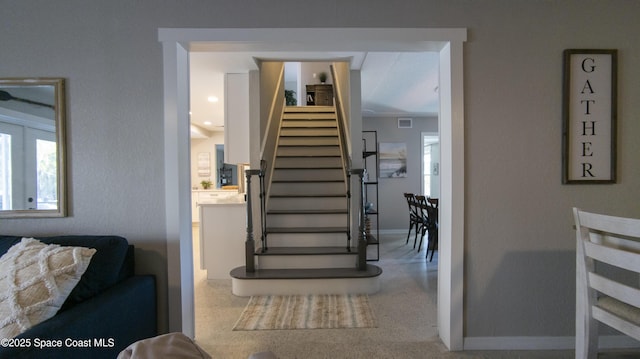 stairway featuring visible vents, speckled floor, and baseboards