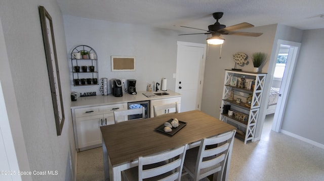 dining room with wine cooler, baseboards, and light speckled floor