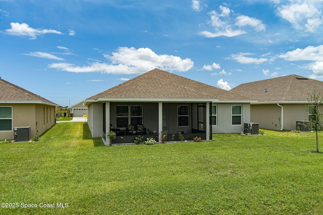 rear view of house featuring a shingled roof, a yard, central AC, and stucco siding