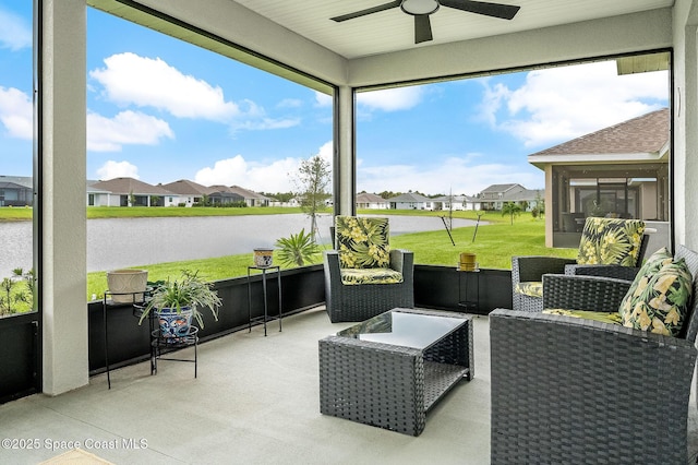 sunroom featuring a residential view, a water view, and ceiling fan