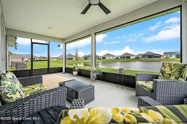 sunroom / solarium featuring a residential view, a ceiling fan, and a water view