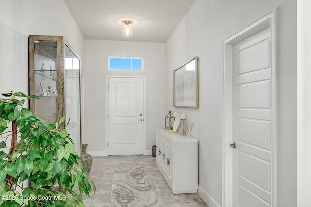 foyer entrance featuring visible vents and baseboards