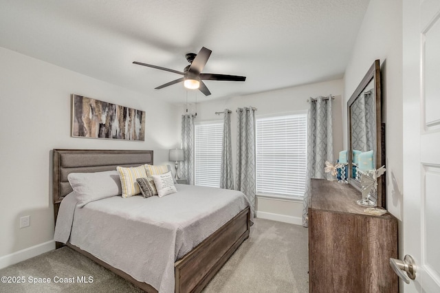 bedroom with light colored carpet, baseboards, and ceiling fan